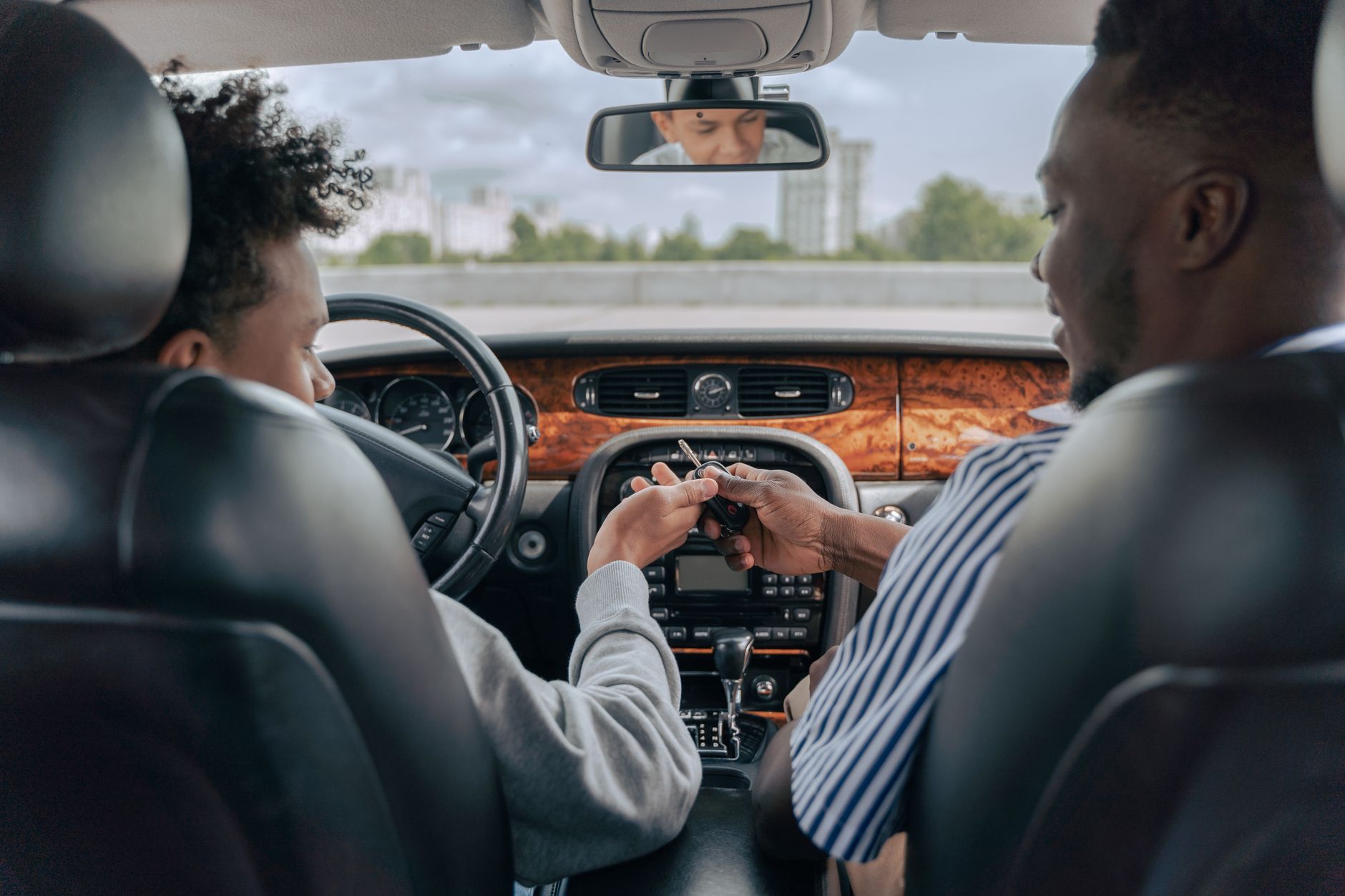 A parent sitting in the passenger seat while a young person learns to drive