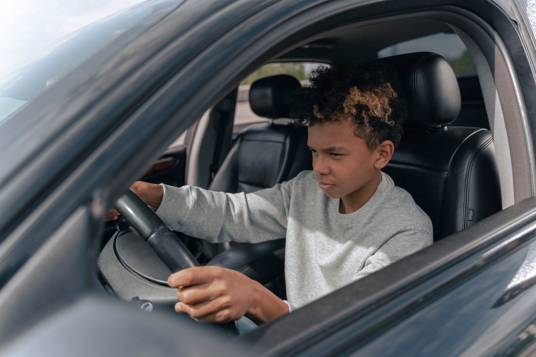 A learner driver concentrating at the wheel on a first lesson