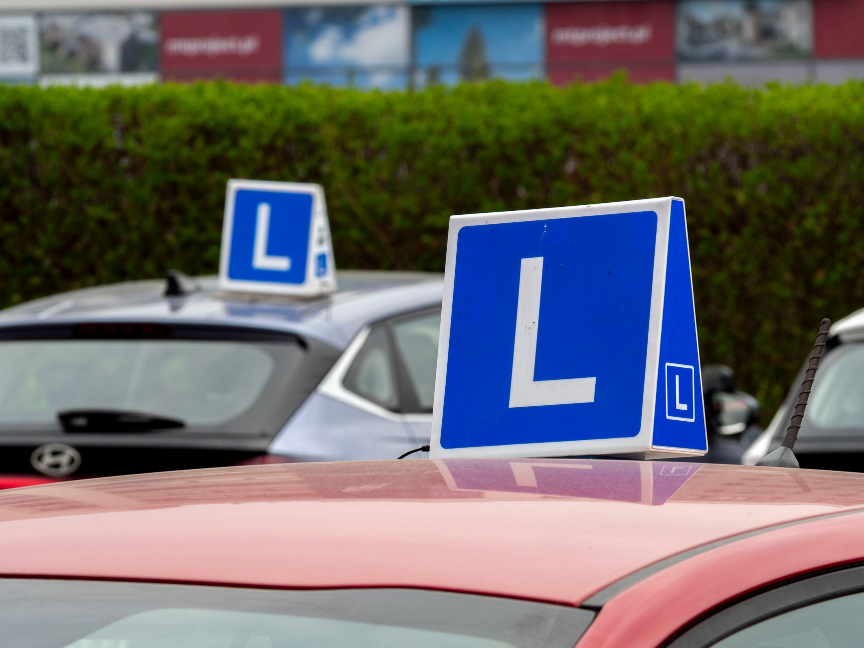Learner cars with L-plates parked at a driving-school training area