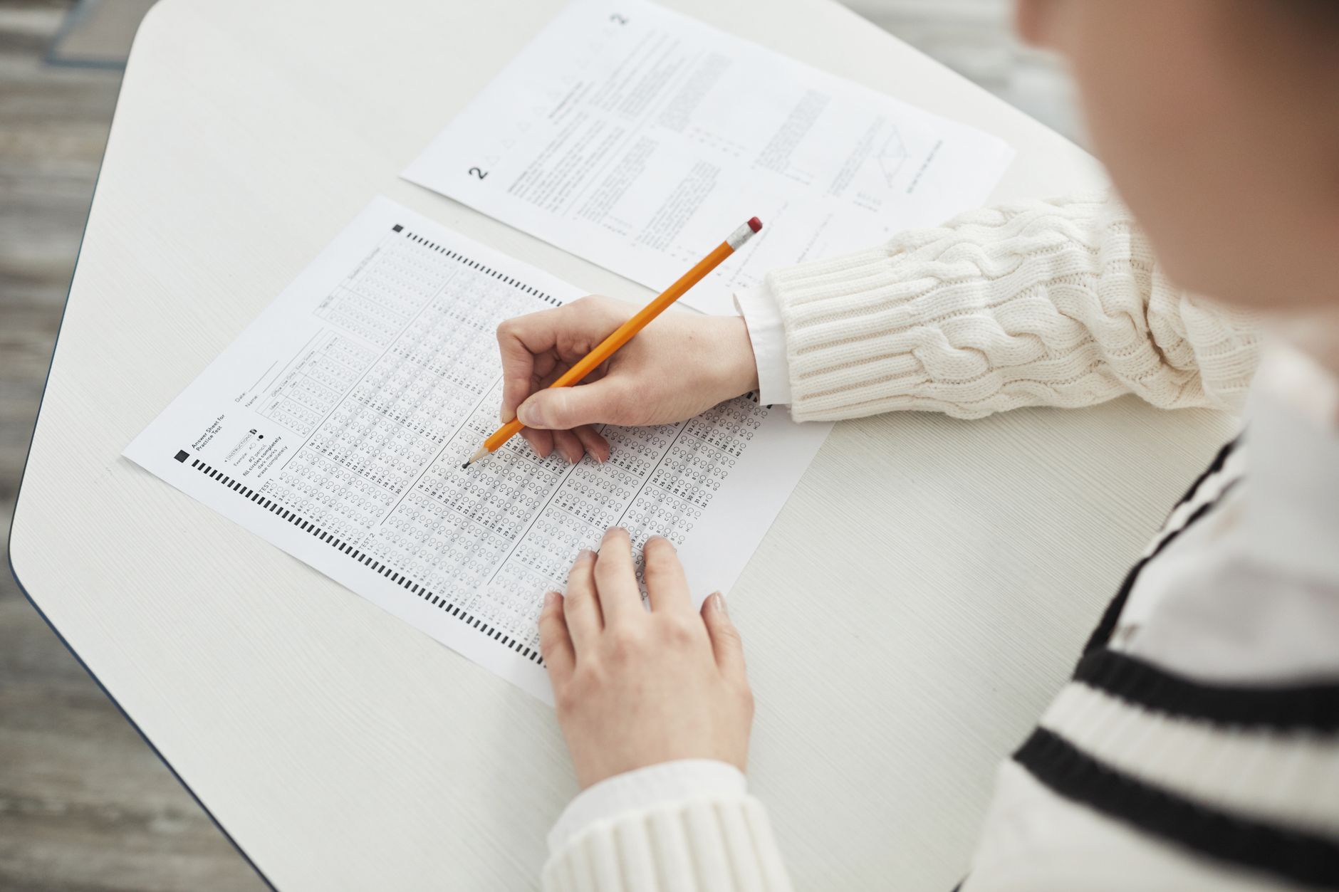 A person sitting a multiple-choice test at a desk